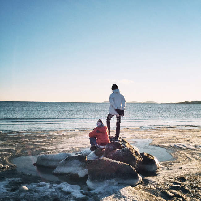 Хлопчики на каменях морем — стокове фото