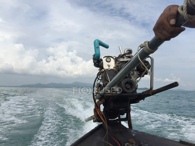 Человек управляет моторной лодкой — стоковое фото