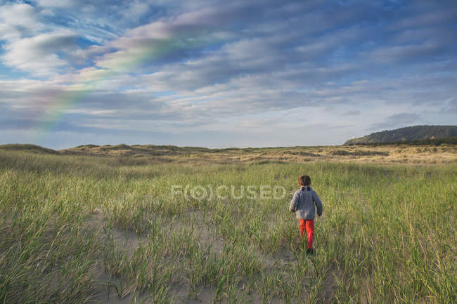 Хлопчик біжить через стоять дюни — стокове фото