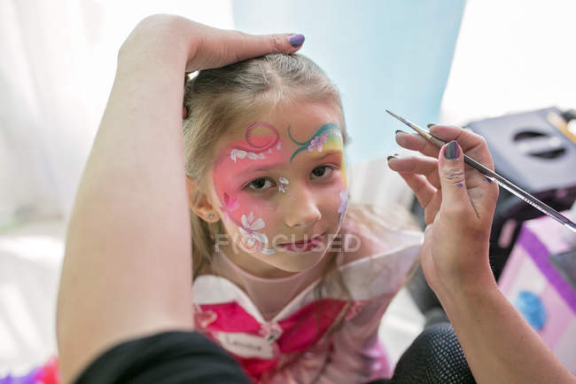 Little girl having face painted — Stock Photo