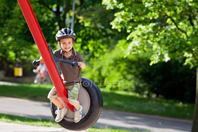 Хлопчик на гойдалці в парку — стокове фото