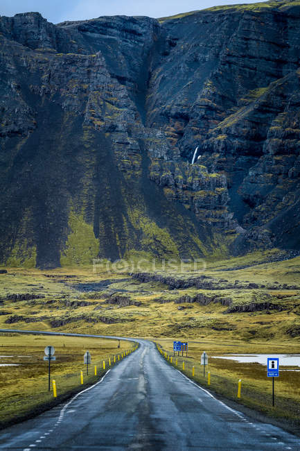 Camino vacío y montañas rocosas - foto de stock