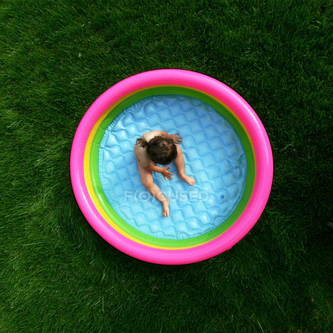 Menina sentada na piscina de preenchimento — Fotografia de Stock