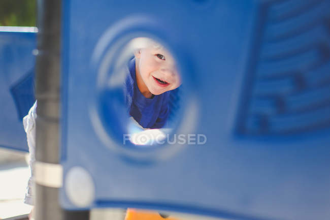 Мальчик смотрит сквозь дыру — стоковое фото