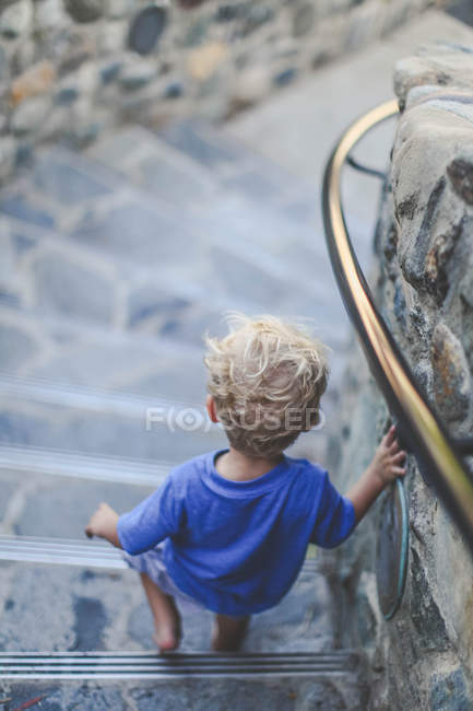 Boy walking down stairs — Stock Photo
