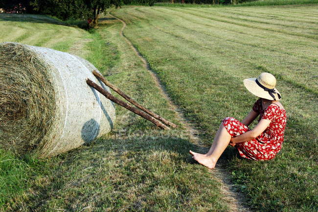 Menina sentada em campo — Fotografia de Stock