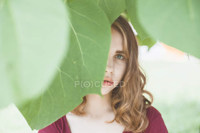 Frau mit von Blättern verdecktem Gesicht — Stockfoto