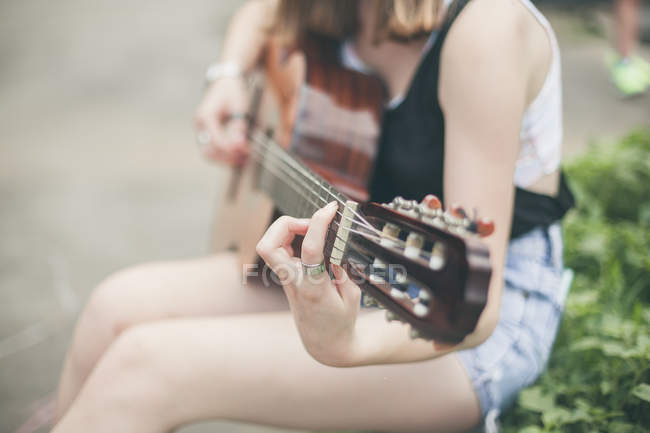 Молода жінка грає на гітарі — стокове фото