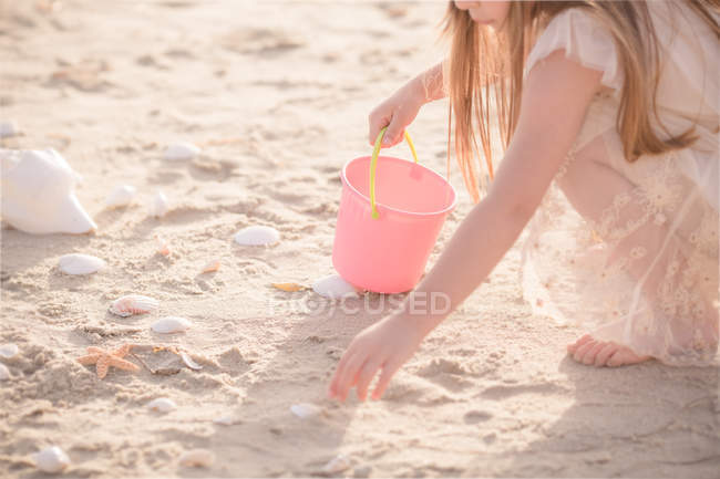 Fille collecte coquillages — Photo de stock