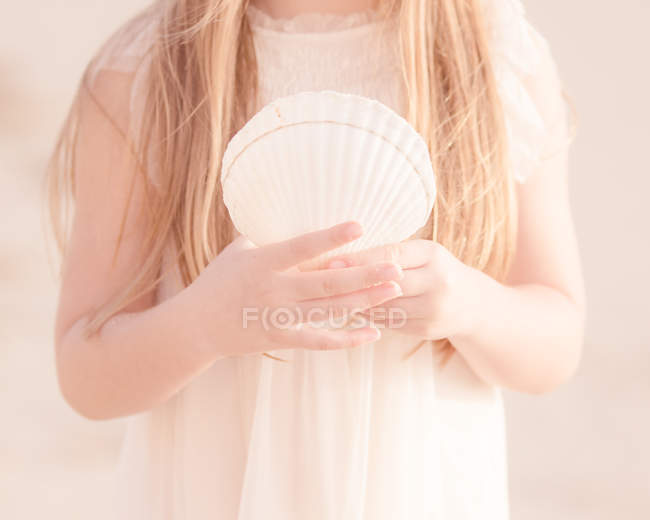 Girl holding seashell — Stock Photo