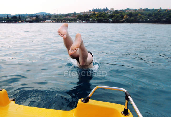 Ein Mann springt ins Wasser, Gardasee, Italien — Stockfoto
