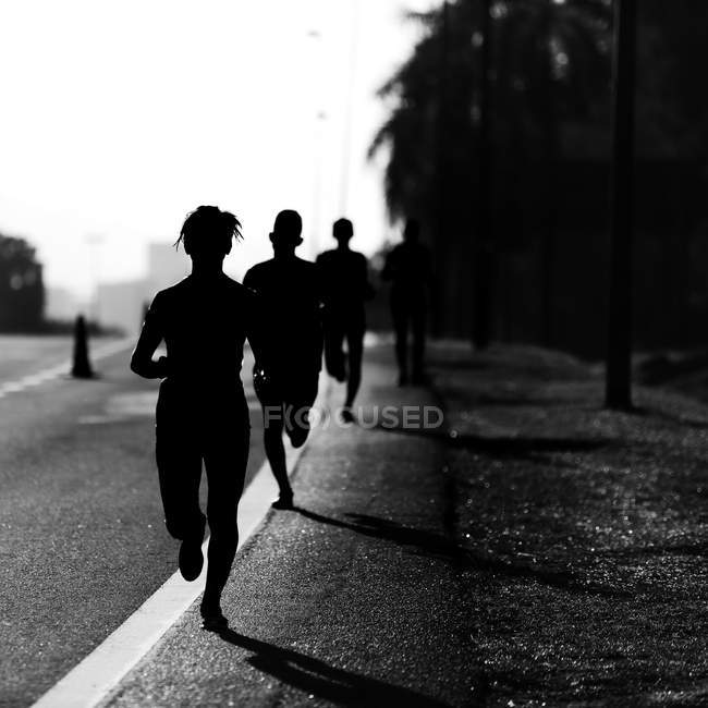 Силуэт бегущих марафон — стоковое фото