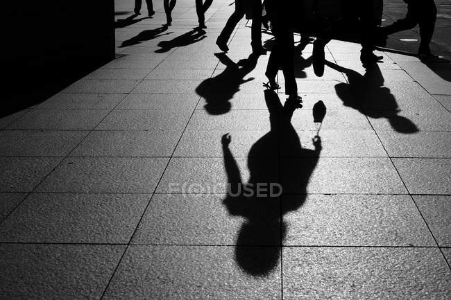 Sombras y siluetas de la gente en la calle - foto de stock