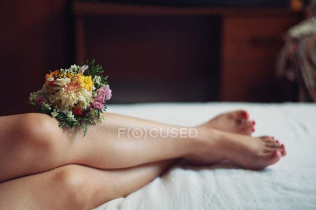 Woman's legs with flowers — Stock Photo