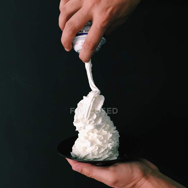 Hand holding whipped cream — Stock Photo