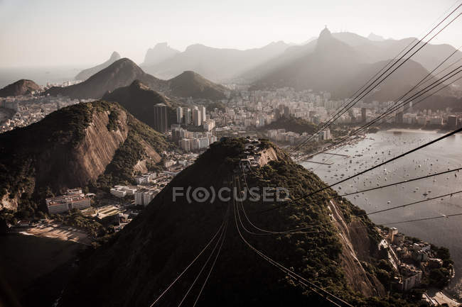 Wires over hills and buildings on coastline — Stock Photo