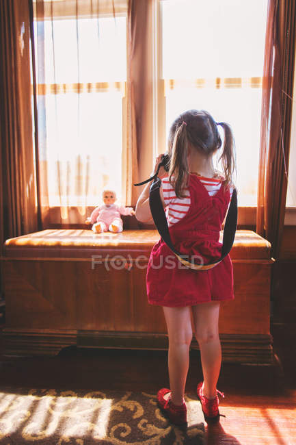 Menina tirando foto de boneca de brinquedo — Fotografia de Stock