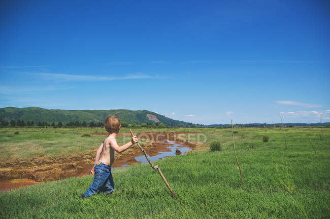 Хлопчик з палицею ходьби — стокове фото