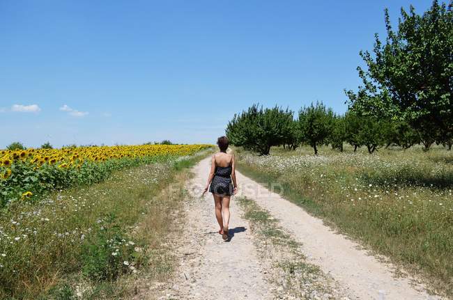 Giovane donna che cammina lungo il sentiero — Foto stock