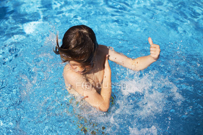 Мальчик брызгает водой — стоковое фото