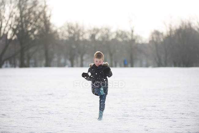 Niño jugando en la nieve - foto de stock