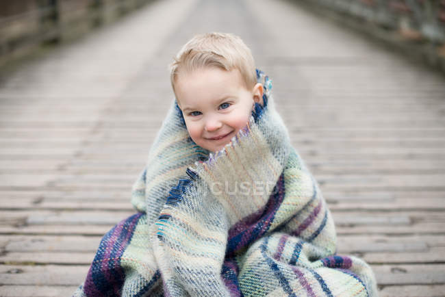 Boy wrapped in blanket — Stock Photo
