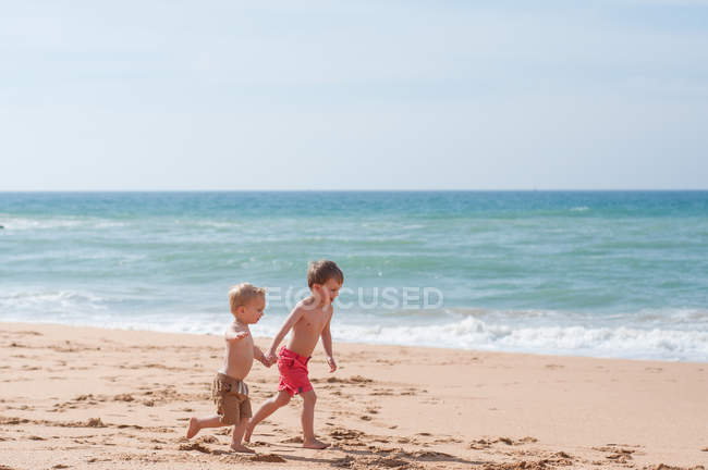 Два хлопчики біжать на пляжі — стокове фото