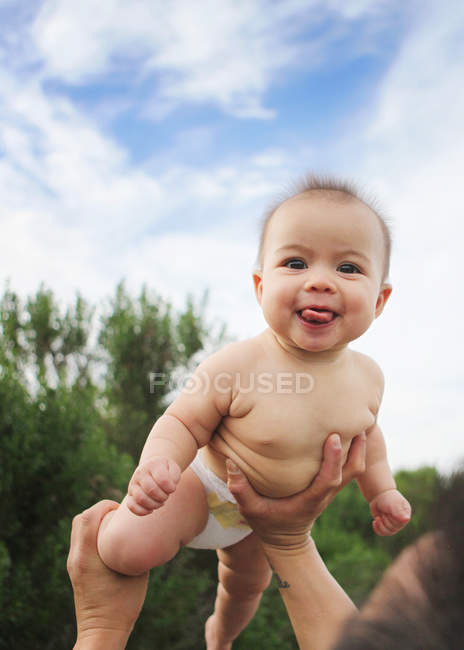 Father lifting baby girl in air — Stock Photo