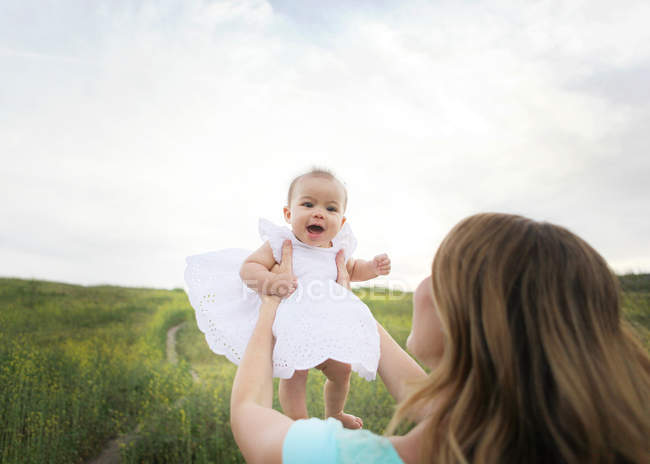 Mamma sollevamento bambina — Foto stock