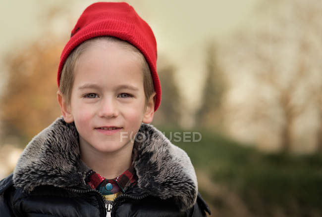 Улыбающийся мальчик в красной шляпе — стоковое фото