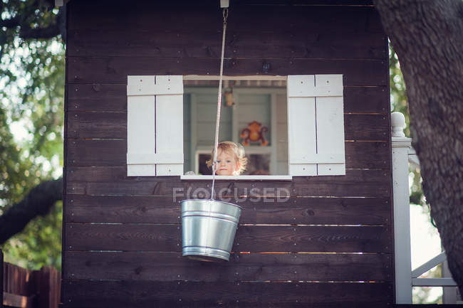 Хлопчик в дереві будинку — стокове фото