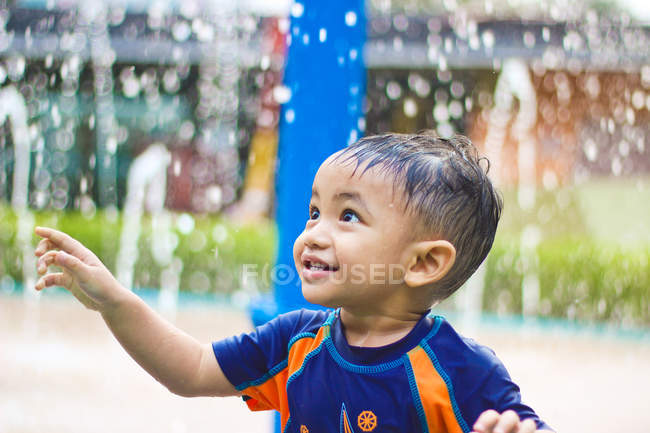Хлопчик стоїть в фонтан — стокове фото