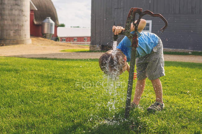 Junge setzt Kopf unter Wasserhahn — Stockfoto