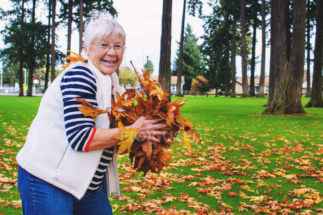 Senior woman holding leaves — Stock Photo