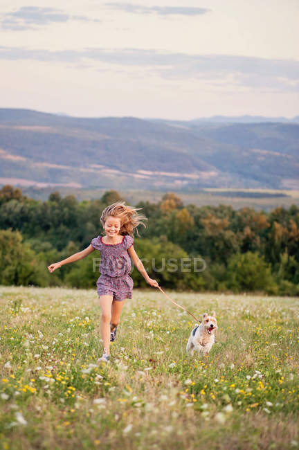 Fille courir avec son renard terrier — Photo de stock