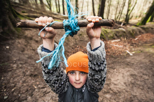 Мальчик играет и висит на веревке — стоковое фото
