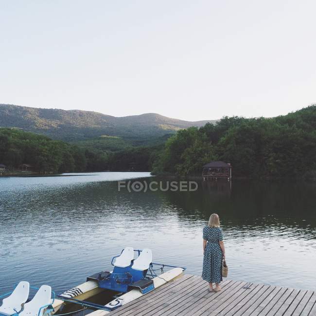 Donna in piedi sul molo — Foto stock