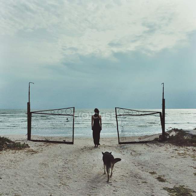 Woman at the beach with dog — Stock Photo