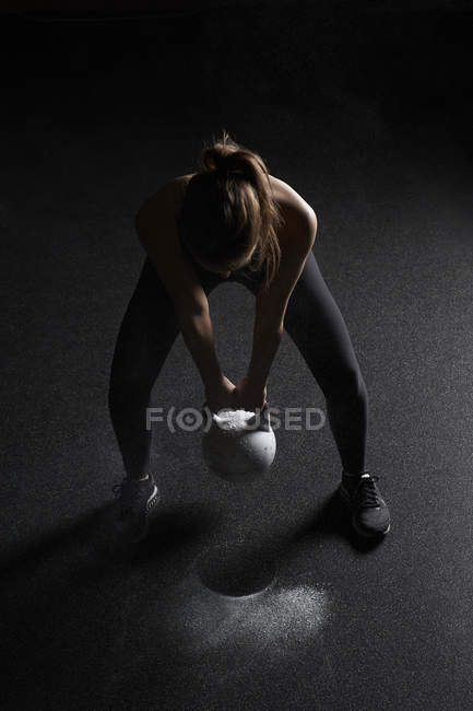 Woman Preparing to lift kettle bell — Stock Photo