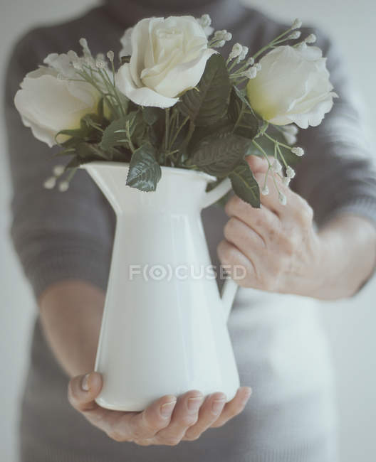 Uomo che tiene brocca di fiori — Foto stock