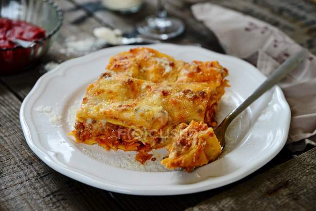 Plate of lasagne with piece on fork — Stock Photo