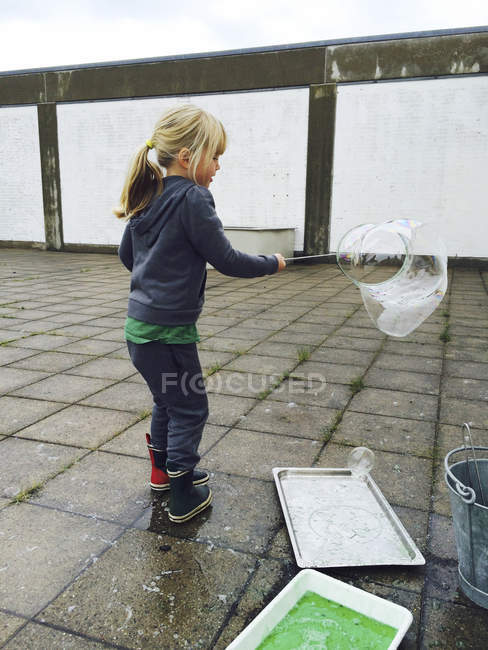 Chica jugando con burbujas de jabón - foto de stock