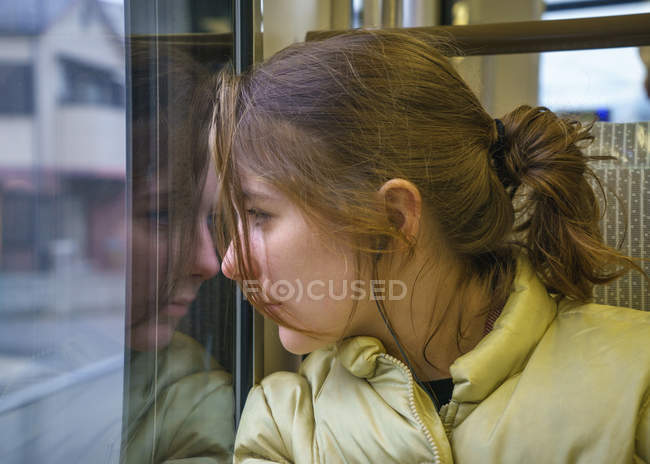 Teenage girl looking through train window — Stock Photo
