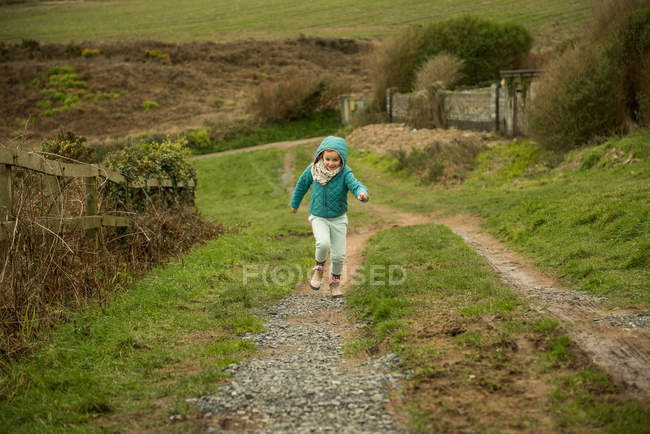 Chica corriendo por una colina - foto de stock