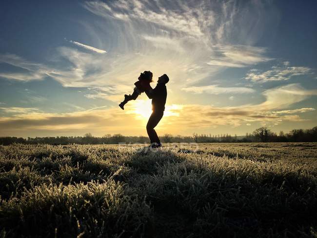 Silhouette of father lifting daughter — Stock Photo