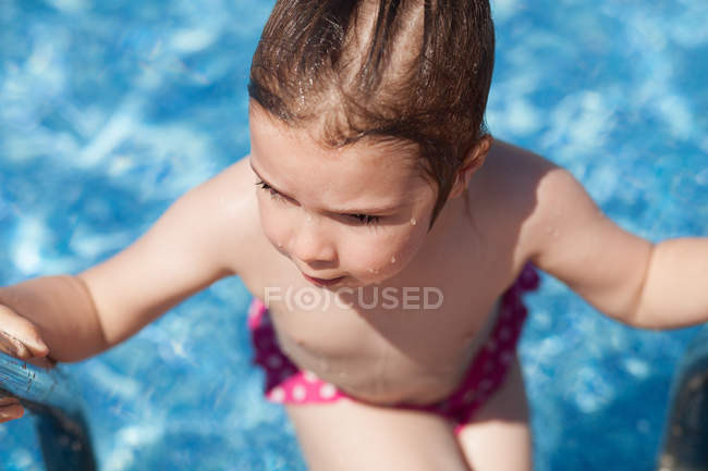 Girl getting out of swimming pool — Stock Photo