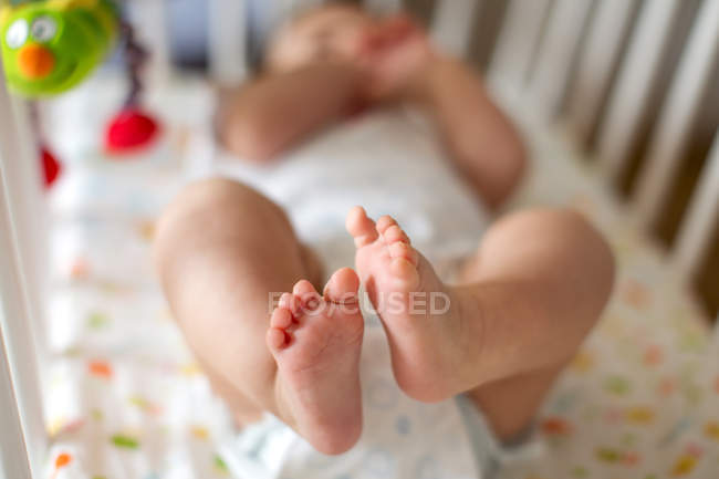 Baby boy lying on crib — Stock Photo