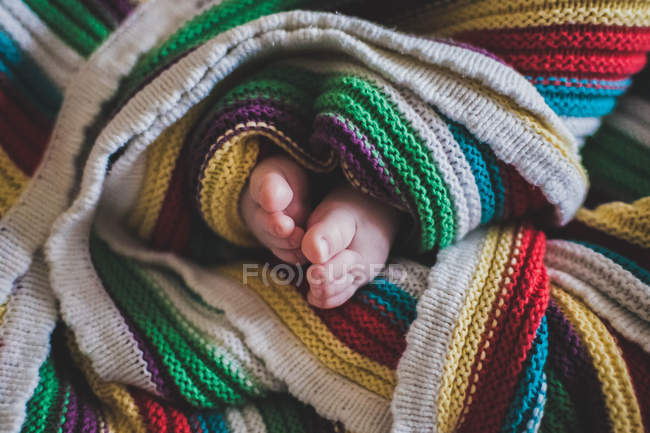 Pieds de bébé enveloppés dans une couverture — Photo de stock