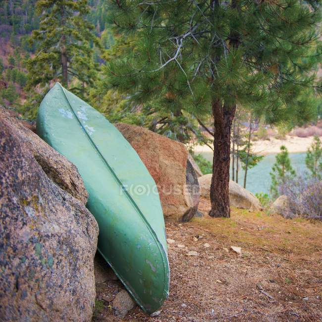 Canoe leaning against rocks — Stock Photo