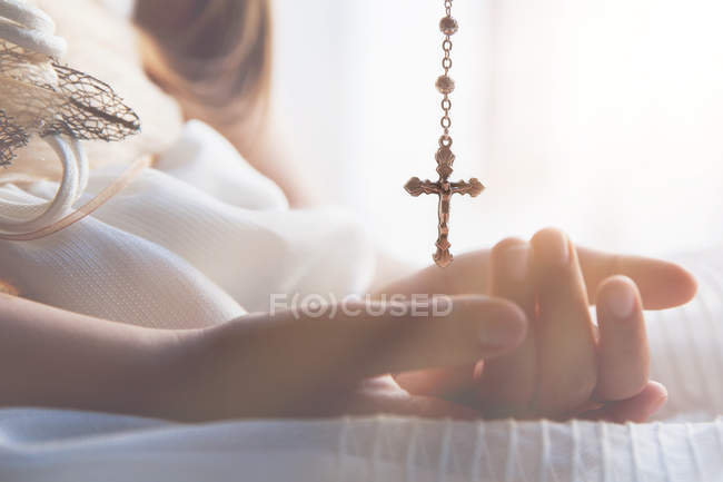 Girl holding necklace with crucifix — Stock Photo